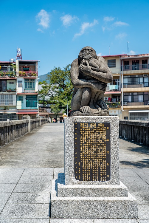 猿の石像をのせた橋の由来を示す記念碑
